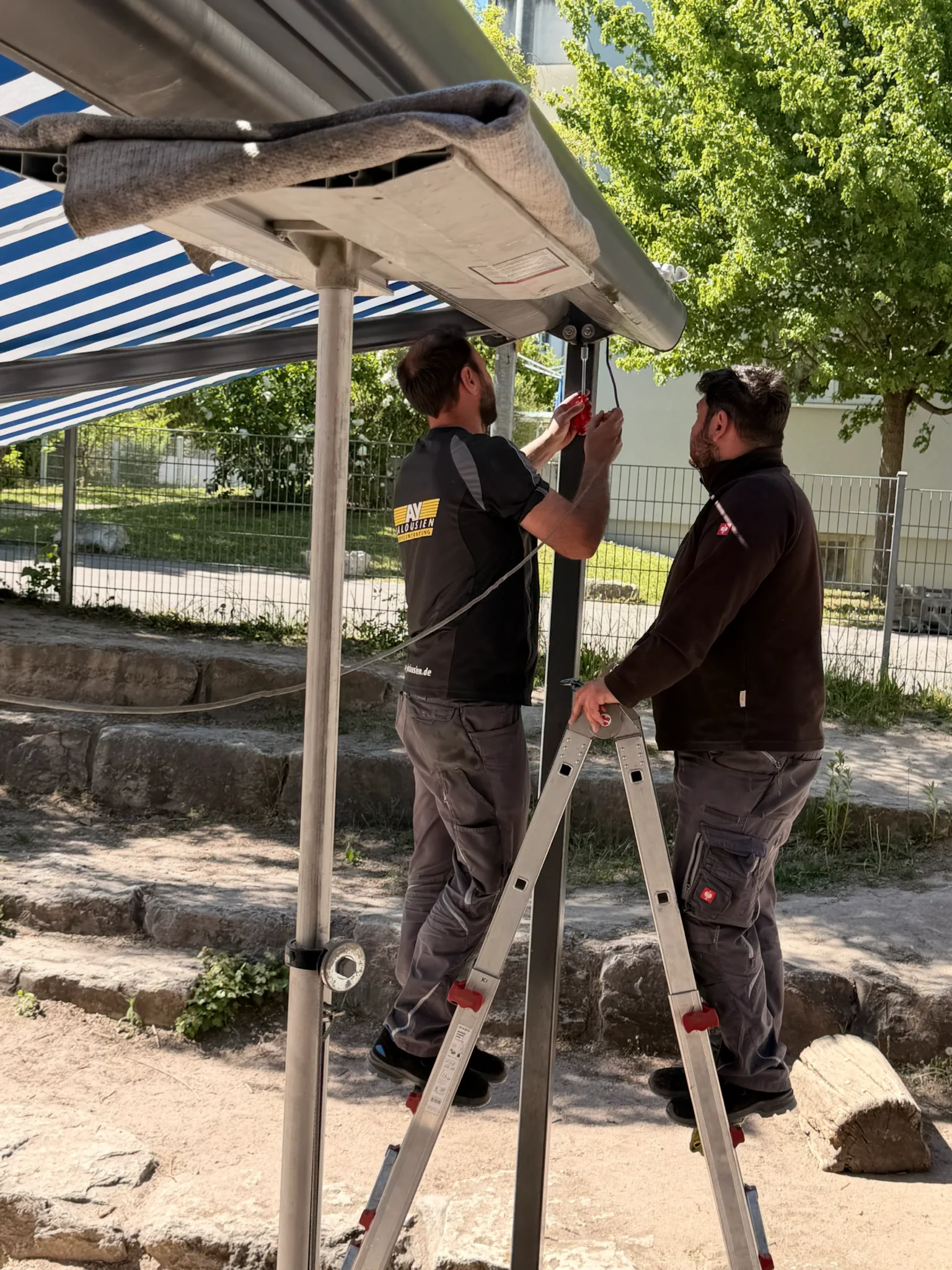 Zwei AY-Techniker bei der Reparatur einer Markise