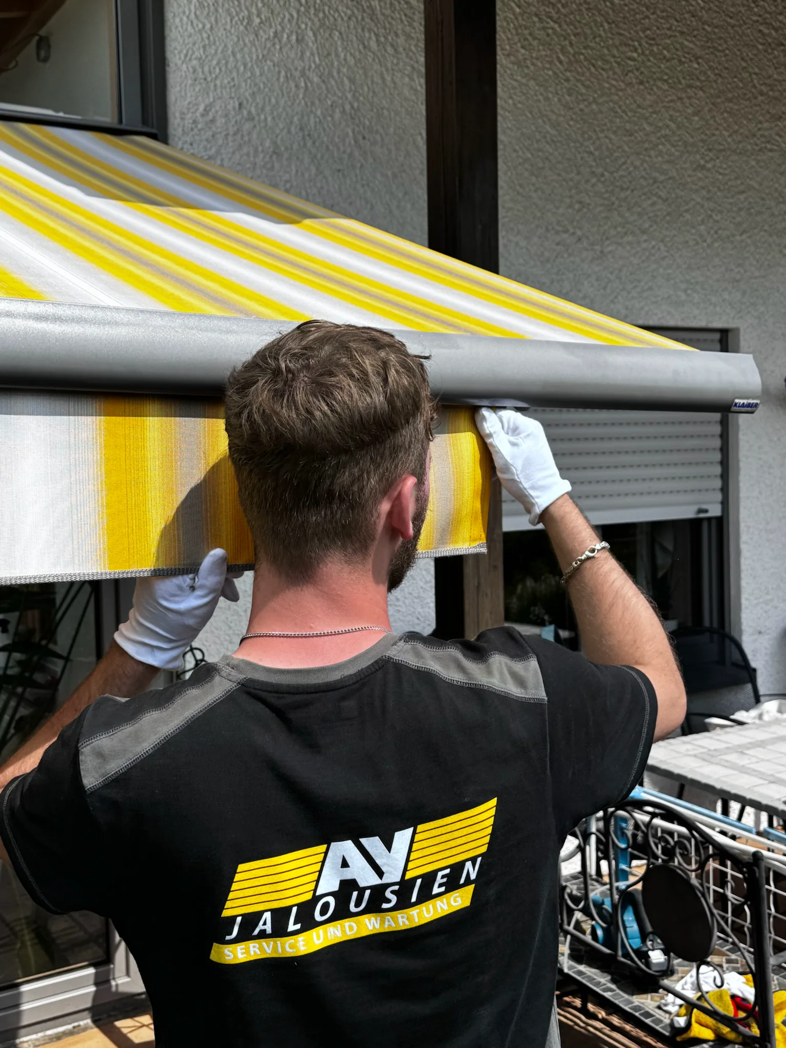 AY-Techniker montiert ein Markisentuch